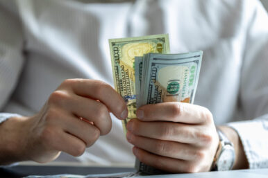man counting hundred dollar bills. dollar investment and cost of living
