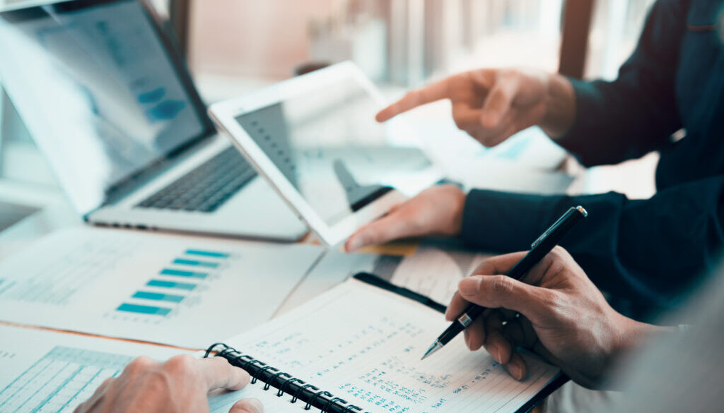 Business partnership coworkers writing cost work progress and us