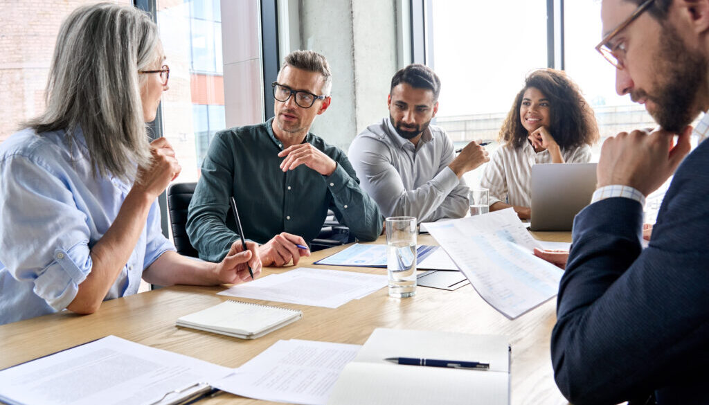 International business executive team having discussion at boardroom meeting.