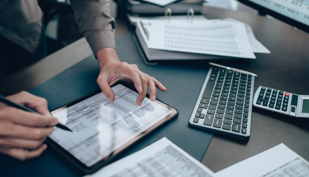 Investors working on desk office and use tablet to check tracki