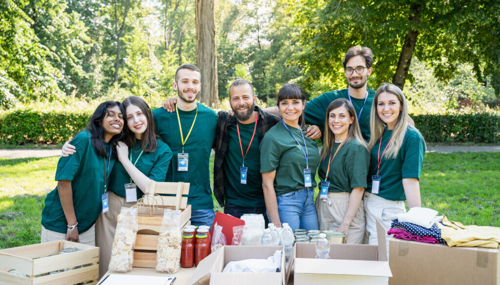 Portrait of a group of volunteers in uniform during a food bank charity event, donating basic necessities for the needy
