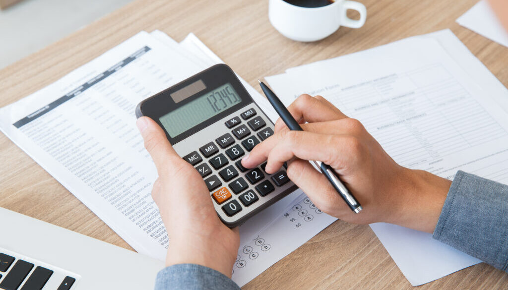 Man using calculator to count income and outcome