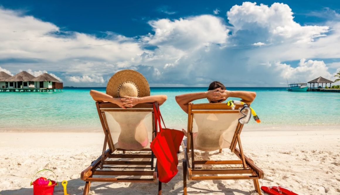 man-and-woman-relaxing-in-lounge-chairs-on-a-beach-in-the-maldives-mature-couple-vacation-early-retirement